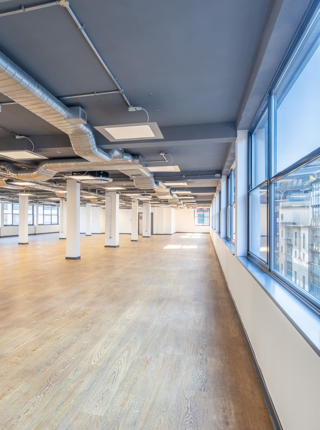 Perimeter corridor of a typical floor showing exposed services and natural light